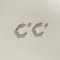 Macro shot of silver wave-shaped C-hoop earrings with small inlaid crystals - Silver White Zirconia (PEK1654)
