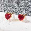 Gros plan sur les puces d'oreilles cœur en acier plaqué or 18k et pierres rouges - Cœur en zircone rouge