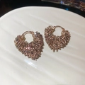Dettaglio macro di orecchini a cuore con perline di cristallo champagne e oro rosa - Champagne Chiaro