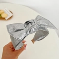 Macro shot of silver wide headband featuring a large metallic textured bow detail - Leather Bow Headband / Silver