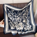 Detail of floral printed navy silk square scarf draped on a leather sofa surface - Thistle Floral Print Navy Blue (XW-195)