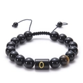 Macro detail of black agate beaded bracelet featuring a gold letter O and tiger eye stone - Letter O
