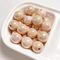 Macro shot of 14mm iridescent champagne gold acrylic beads in a ceramic bowl - Milk Tea