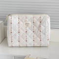 Detail of fabric makeup bag with floral print and diamond stitching on white background - Red Flower Clutch Bag (Medium Flat)