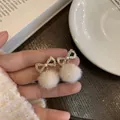 Boucles d'oreilles nœud doré avec pompons en fourrure blanche et perles élégantes - Nœud en Strass Boule de Poils Beige (1760)