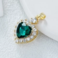 Pendentif cœur doré avec grand zircon vert et halo de cristaux blancs sur fond blanc - Zircon Rouge