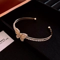 Detailed view of a gold-plated butterfly bangle featuring shimmering cubic zirconia stones - Gold
