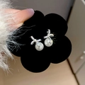 Detalle de los pendientes de lazo plateados con circonitas brillantes y perla blanca - Estilo de Lazo Plateado (HE28946)