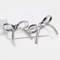Elegant silver textured bow knot dangle earrings for women on white display card - White Gold