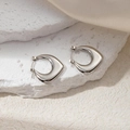 Detailed view of silver geometric earrings on a white stone and beige satin background - Irregular Triangle Earrings (0219)