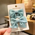 Pair of light blue ribbon bow hair clips on a white display card for baby girls - Green