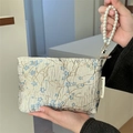 Portable cream clutch bag with blue floral embroidery and pearl wristlet strap - Blue Plum Blossom
