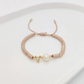 Detail of hand-woven pink rope bracelet featuring letter V charm and natural pearl - Letter V