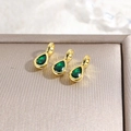 Detailed macro view of 18k gold plated teardrop pendants with green zircon stones - Green
