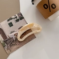 Detail der übergroßen cremefarbenen Acetat-Haarklammer mit Creation France Logo - Creme Blumig