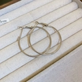 Close-up of sleek silver hoop earrings resting on a beige velvet jewelry display tray - Silver Earring Post Regular Silver Hoop