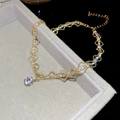 Détail d'un collier doré à double rangée ondulée avec pendentif en zircon brillant sur velours - Doré