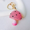 Dettaglio portachiavi a fungo in resina rosa con strass scintillanti e piccoli pois neri - Fungo Singolo / Rosa