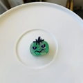 Detalle de pinza de pelo de Halloween con purpurina verde, ojos púrpuras y cara graciosa - Mini Calabaza Diablo Verde