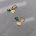 Détail de boucles d'oreilles cœur doré avec motif étoile et pierres naturelles vertes - Style Coeur