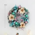 Christmas wreath with pink and blue ornaments, golden flowers, and snowy pine needles - Blue Pink Wreath 30cm