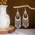 Close-up of ethnic silver peacock tassel earrings hanging on natural wooden branches - Silver Floral Hollow Pendant(E2875-17)