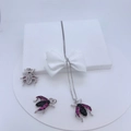 Macro shot of silver insect pendants with black and pink zircon stones on white stand - Beetle Style Silver With Pink/Black Stones (#8)