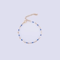 Detailed view of a gold-plated bracelet featuring deep blue enamel oval beads and lobster clasp - Gold + Royal Blue