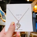 Halskette mit silbernem Delfin-Anhänger und Mikro-Kristallen auf weißer Displaykarte - Silber Fische Stil