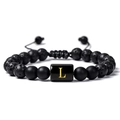 Détail macro du bracelet en pierre de lave avec perle dorée gravée de la lettre L - Lettre L(L)