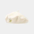 Detailed view of beige beret hat featuring small yellow banana embroidery and wool texture - White