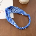 Elastic wide navy blue paisley print twist headband on dark wooden background - Sky Blue