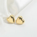 Detalle macro de pendientes de corazón dorados sobre elegante tela de seda blanca - Estilo de Corazón ES2530-1