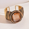 Macro detail of hand-woven gold wire cuff with large amber faceted crystal centerpiece - Gold Square