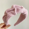 Soft light pink knitted plush headband with twisted knot design for winter styling - Pink
