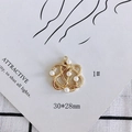 Dettaglio di un ciondolo a fiore dorato 30x28mm con sei perle bianche incastonate - 1# Nodo a Fiore in Perla Traforata
