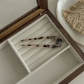 Close-up of tortoise shell U-shaped hair pin resting on a beige velvet jewelry box - Hair Fork