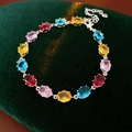 Macro detail of oval colorful zircon stones in four-prong silver settings on a velvet mat - Colorful