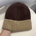 Detalle del tejido de gorro de punto bicolor en marrón oscuro y caqui en tela suave - Talla única / Café y Beige