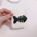 Cute black fishbone hair clip in matte finish shown on a branded display card - Black