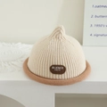 Detail of beige ribbed knit baby beanie with rolled brim and brown logo patch accent - Letter Tag - Beige