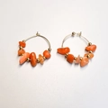 Close-up of bohemian gold hoop earrings with irregular orange stone beads and gold spacers - Red Aventurine