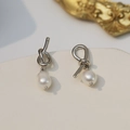 Elegant 925 silver knotted earrings with natural freshwater pearl drops on white pedestal - 925 Silver Needle / Silver
