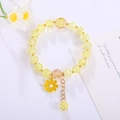 Macro detail of handmade beaded bracelet with yellow crackle crystal and sunflower charm - Yellow