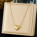 Detalle de un colgante de corazón dorado con circonita en un joyero de satén - Estilo Blanco Transparente (N3974)