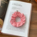 Detail of a pink fabric scrunchie with From Sheep label on an open book page - Pink