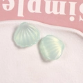 Detalle de dos dijes de resina verde claro iridiscente en forma de concha para joyería DIY - Verde