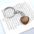 Pendentif cœur en œil de tigre poli avec porte-clés argenté sur fond blanc épuré - Bracelet en pierre œil de tigre