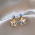 Detail view of star-shaped stud earrings with blue crystals and elegant gold-tone finish - Silver Earring Post - Gold - Blue