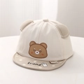 Dettaglio del ricamo a orsetto e orecchie 3D su un cappello da sole per neonati in cotone - Beige